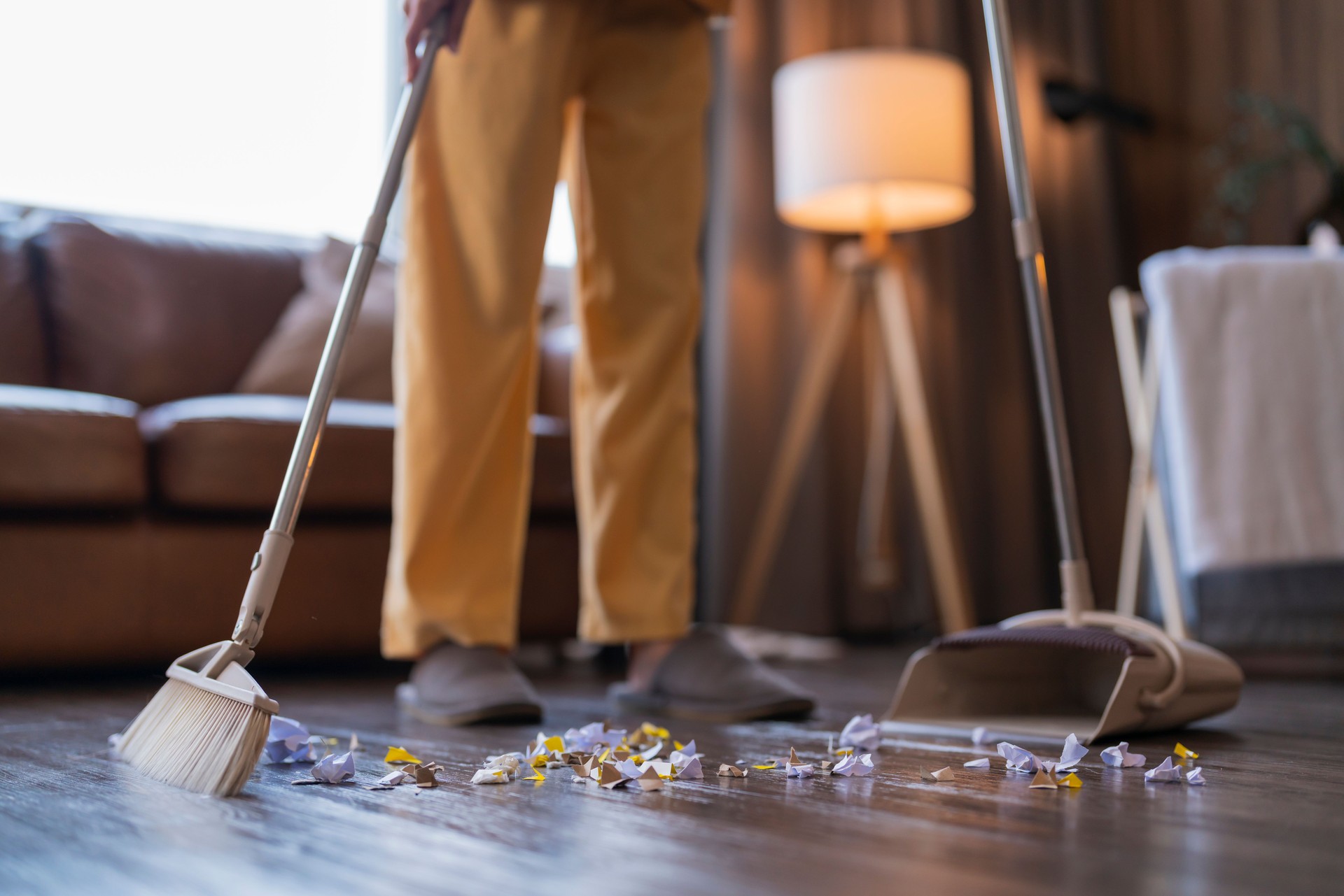 Happiness Asian young adult doing house work sweeping floor with a broom while moving in a new house